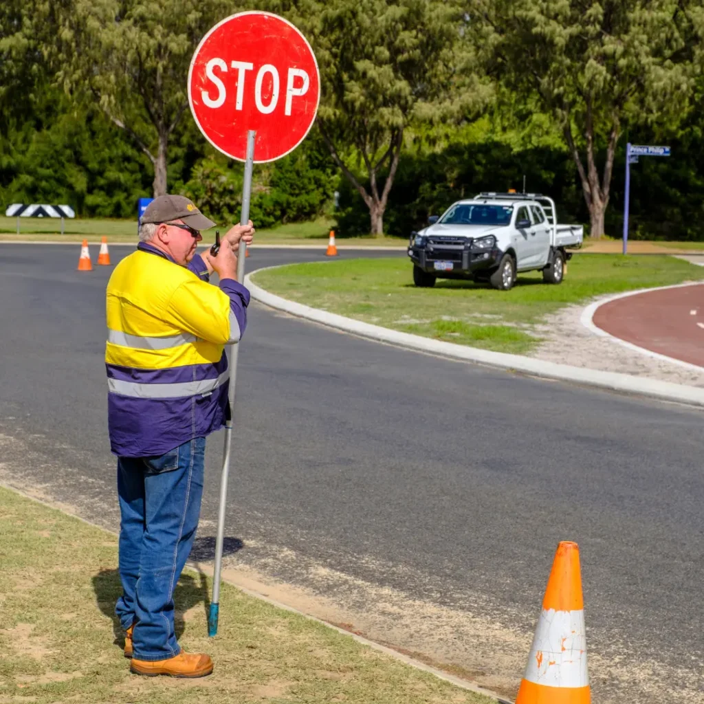 AusQ Training learner holding a stop sign and directing vehicles during practical training for the BWTM and Traffic Controller (TC) course.