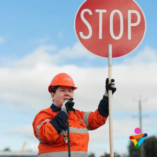 Traffic controller using a STOP sign to manage vehicle movements at a worksite in Bunbury.